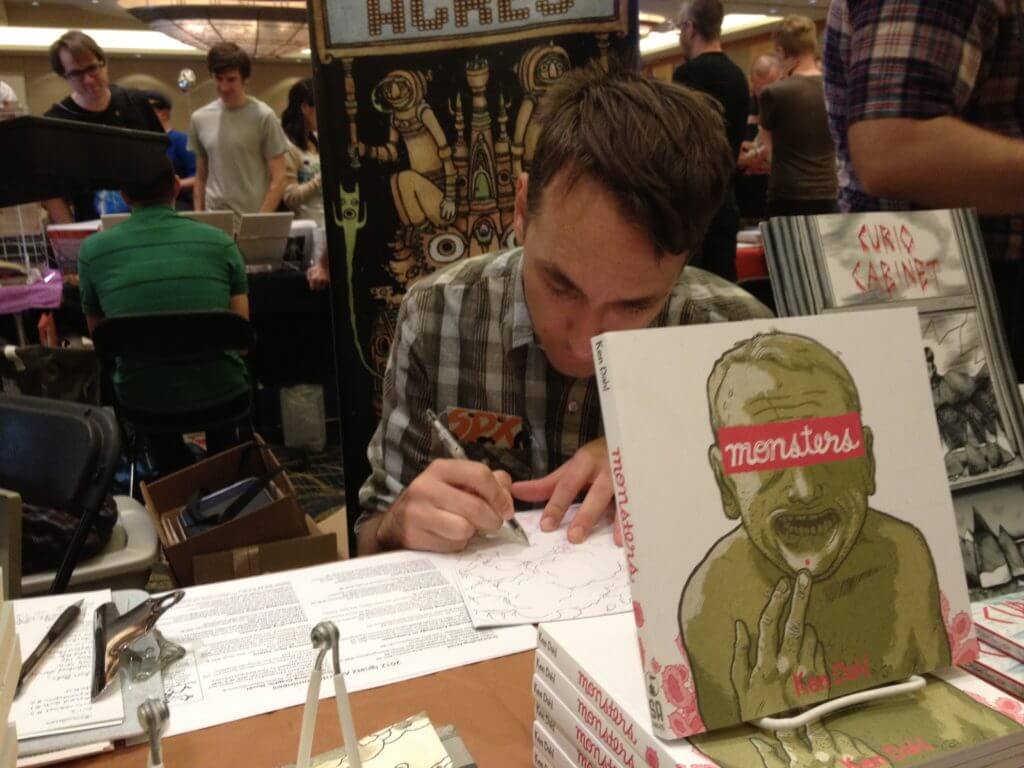 Ken Dahl, aka Gabby Schulz, at a convention with his book Monsters.